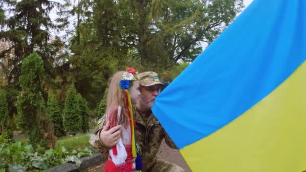 ウクライナの兵士と娘は国の旗にキスをする。ウクライナが好き. - 映像、動画