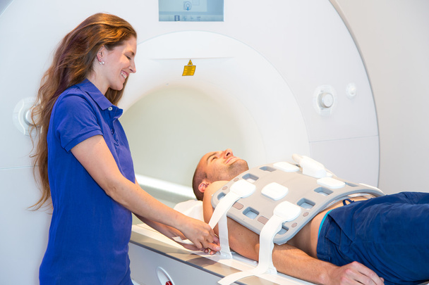 Medical technical assistant preparing scan of torso with MRI - Foto, Imagem
