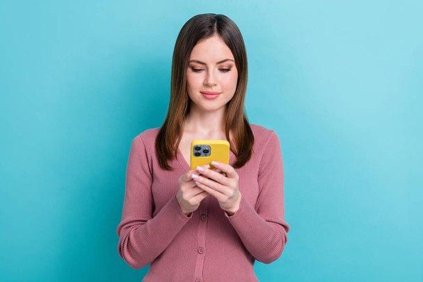 Photo of young focused business worker girl wear pink shirt hold phone write email colleagues from office isolated on cyan color background. - Foto, Imagen