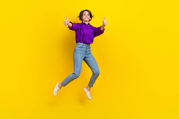 Full body photo of young marketer lady brown bob hair thumbs up jump wear violet shirt rate new office isolated on yellow color background. - Foto, Imagem