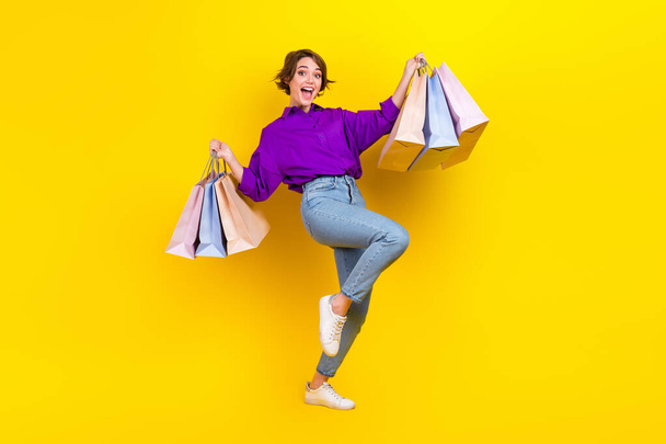 Full length body photo of young carefree addicted shopaholic woman wear formal clothes hold bags boutique isolated on yellow background. - Zdjęcie, obraz
