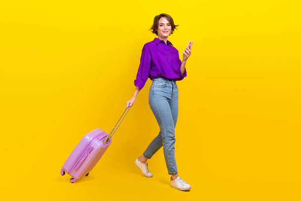 Full size photo of pretty young girl go gadget taxi application wear trendy violet smart casual outfit isolated on yellow color background. - Foto, Bild