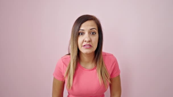 Donna mediorientale in piedi con l'espressione del vincitore su sfondo rosa isolato - Filmati, video