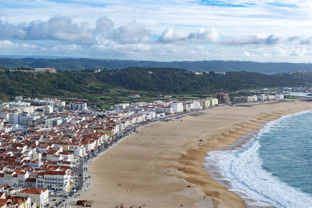 De stad Nazare in Portugal, het symbool van surfen. Kustlijn en uitzicht van bovenaf op de stad. Toeristische plek met grote golven. Landschapsfoto. - Foto, afbeelding