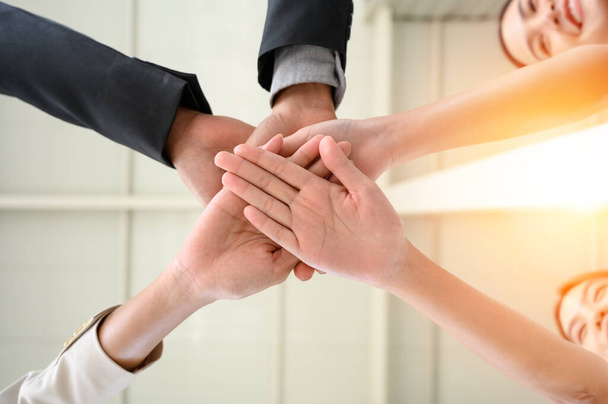 Щаслива об'єднана бізнес команда приєднується до рук як знак ділової командної роботи. складання рук, що святкують перемогу в офісі. концепція успіху бізнесу. вигляд з низьким кутом
 - Фото, зображення