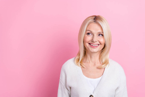 Photo of cheerful positive person beaming smile look empty space isolated on pink color background. - Fotografie, Obrázek