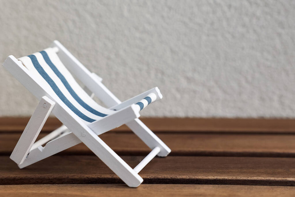 Toy sun lounger on table near light wall - Photo, Image