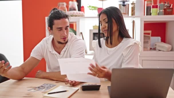 Мужчина и женщина используют бухгалтерский учет ноутбука с беспокойным выражением лица в столовой - Кадры, видео