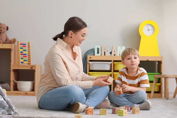 Nounou et petit garçon jouer avec des cubes à la maison - Photo, image