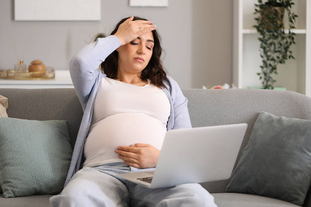 Tired young pregnant woman working with laptop at home - Photo, Image