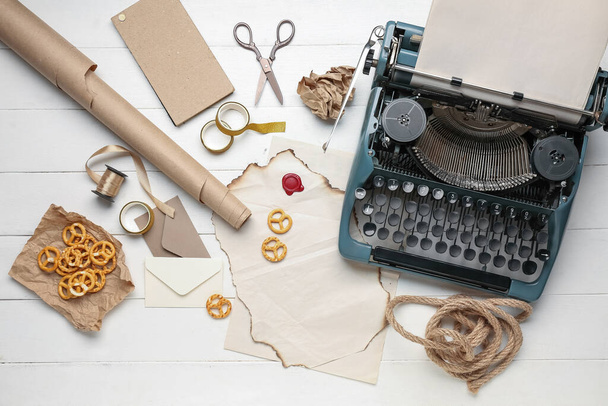 Composição com máquina de escrever vintage, pergaminhos, lanches e tesouras em mesa de madeira branca - Foto, Imagem
