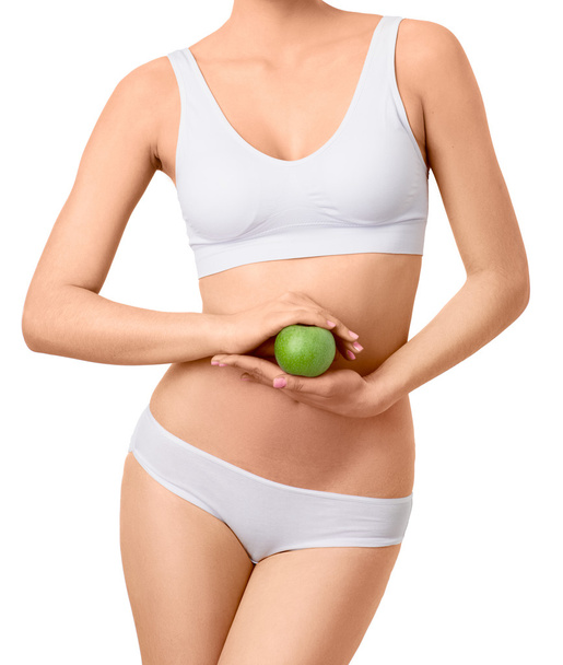 Slim woman in white underwear with green apple at her hands over isolated background - Zdjęcie, obraz