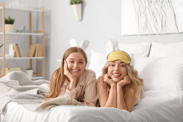 jonge zussen liggend op bed thuis - Foto, afbeelding