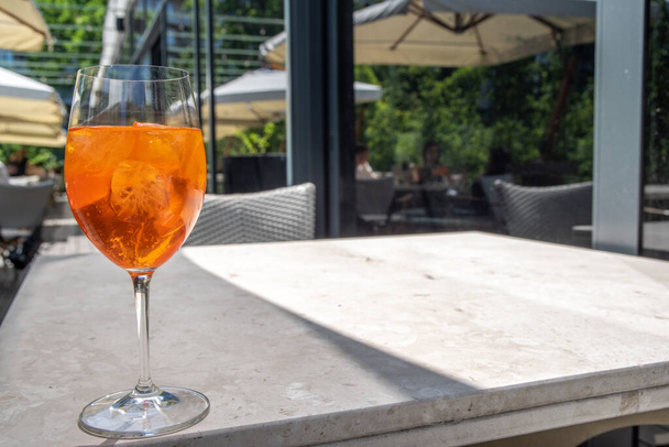 Girl drink iced alcohol Aperol spritz cocktail on summer terrace, in cafe or restaurant - Photo, Image