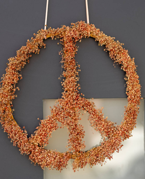 ένα σύμβολο ειρήνης ως διακόσμηση με λουλούδια σε μια πόρτα - Φωτογραφία, εικόνα