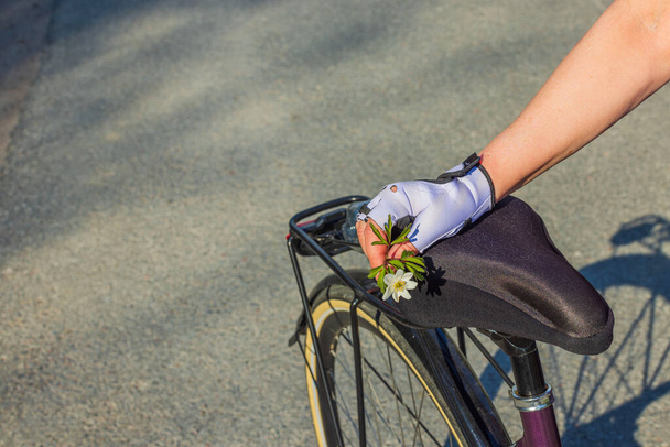 Beyaz çiçek tutan spor eldivenli kadın eli görüntüsü.  - Fotoğraf, Görsel