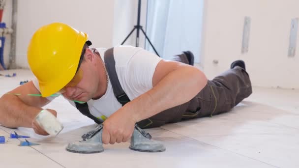 Het handwerkDe ambachtsman legt keramische tegels op de vloer en legt keramische tegels op de vloer. Hoge kwaliteit 4k beeldmateriaal - Video