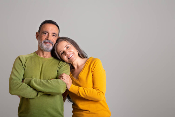 Cheerful european old husband and wife enjoy date together at spare time on gray studio background, free space. Family relationship, romance and positive, lifestyle, ad and offer - Foto, Imagen