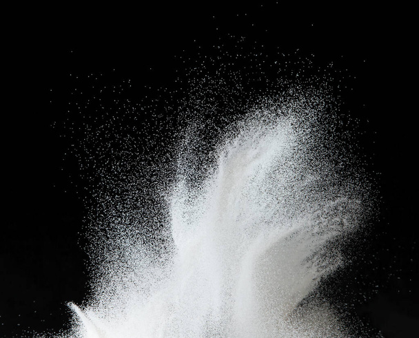 Εκατομμύρια άσπρη άμμο έκρηξη, Φωτογραφία από πτώση κάτω χιόνι ντους, βαριά χιονοθύελλες πετούν. Παγωμένη βολή σε μαύρο φόντο απομονωμένη επικάλυψη. Μικροσκοπική λεπτή άμμος ως επιστήμη σωματιδίων - Φωτογραφία, εικόνα