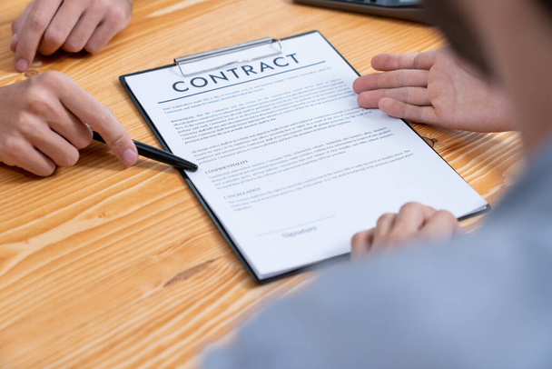 Businessman carefully reviewing contract document for corporate partnership. Client reading agreement deal and terms on meeting table for professional business decision. Entity - Photo, Image