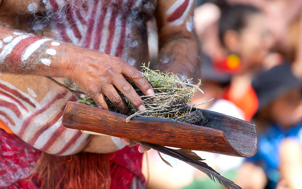 Ceremonia Indígena Australiana, mano de hombre con ramas verdes y llama, enciende un fuego para un rito ritual en un evento comunitario en Adelaida, Australia Meridional - Foto, imagen