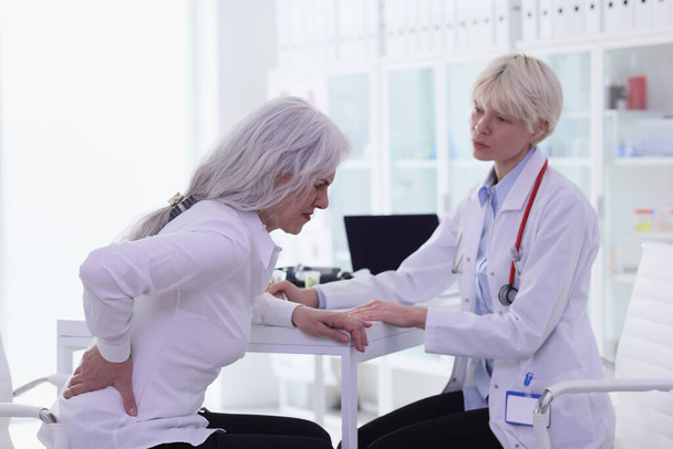 Seniorin mit starken Rückenschmerzen besucht Ärztin im Krankenhaus Älterer Patient leidet unter Rückenschmerzen bei Hausarzttermin - Foto, Bild