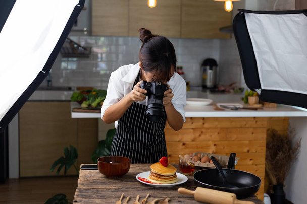 写真家の食べ物アジアの女性はスタジオで食べ物の写真を撮っています. - 写真・画像
