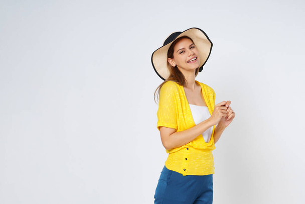 Νεαρή γυναίκα με πολύχρωμα ρούχα και καπέλο ήλιο, απομονωμένη σε λευκό φόντο.Lifestyle έννοια του καλοκαιριού. - Φωτογραφία, εικόνα