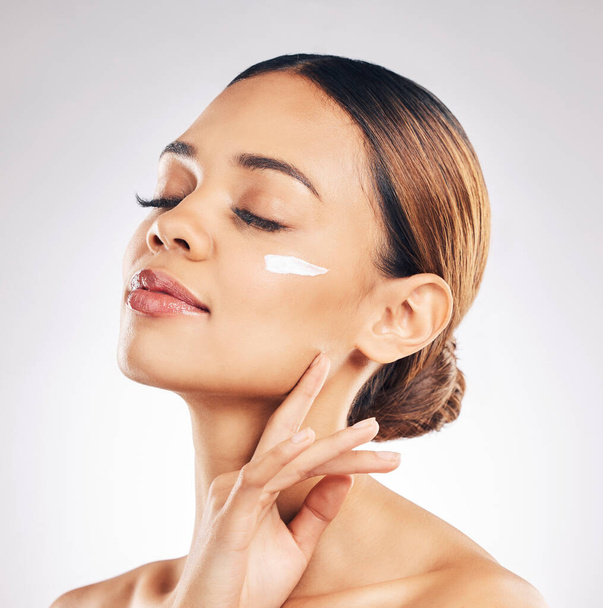 Skincare, face cream and woman relax in studio for cosmetic, wellness or self love on grey background. Facial, beauty and female model with sunscreen, moisturizer or collagen mask for hydration. - Photo, Image