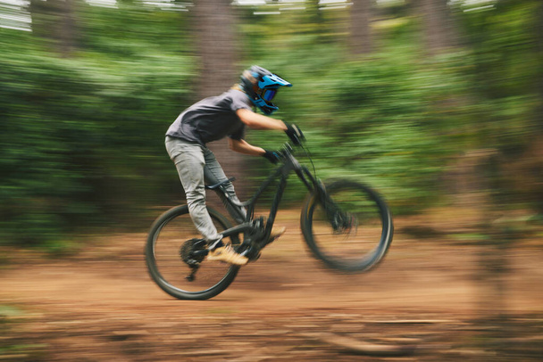 Urheilu, pyörä ja mies tekee adrenaliini temppu energiaa ajettaessa nopeasti kilpailun käytännössä metsässä. Kunto, hämärä liike ja mies urheilija biker koulutusta tai liikuntaa ulkona metsässä. - Valokuva, kuva