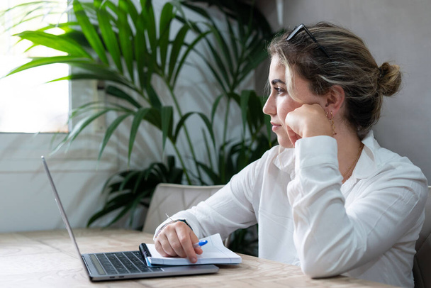 Portré komoly Y-generációs kaukázusi diáklány ül íróasztal otthoni tanulmány online laptopon. Figyelmes fiatal vonzó nő használja a számítógépet, hogy távoli tanfolyam vagy képzés. Oktatási koncepció. - Fotó, kép