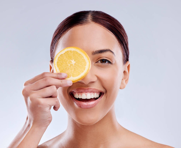 Skincare, portrait or happy girl with orange or natural facial with citrus or vitamin c on studio background. Wellness, smile or healthy woman smiling with organic fruits for dermatology beauty. - Fotografie, Obrázek