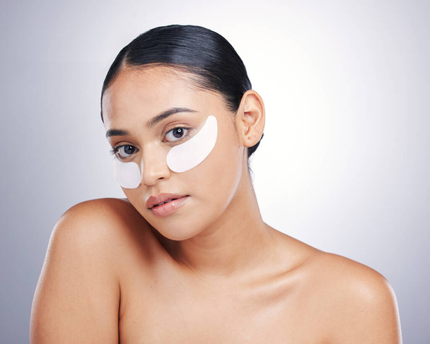 Face, eye mask and beauty of a woman in studio for glow, dermatology or natural cosmetics. Portrait of model person with collagen skincare patch for facial self care or wellness on a white background. - Photo, image