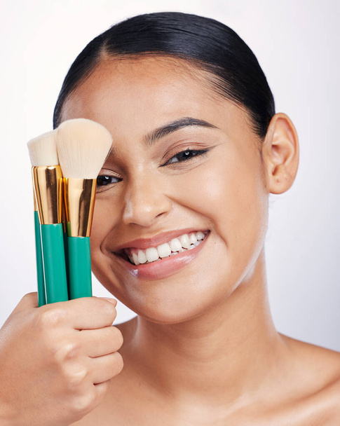 Brush for makeup, face and beauty with happy woman, foundation and portrait isolated on studio background. Female model smile, natural cosmetics and skin glow with cosmetic tools and cosmetology. - Fotó, kép
