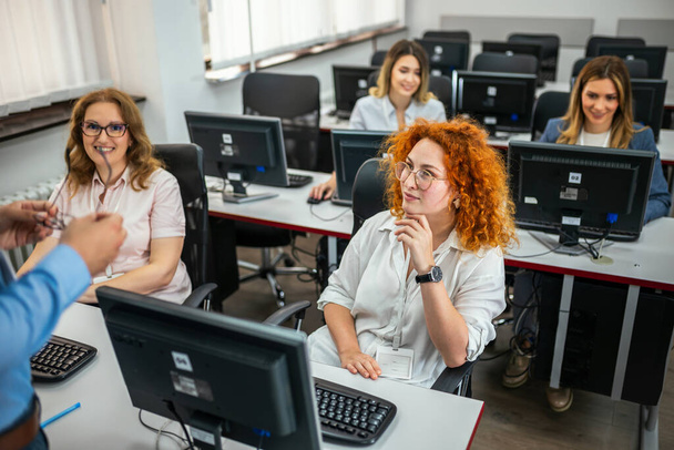 Image of young people sitting at the tables in computer class - Photo, Image
