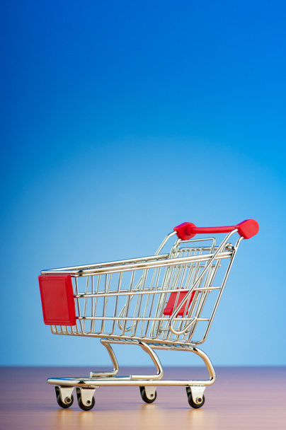 Mini shopping cart against gradient background - Photo, Image