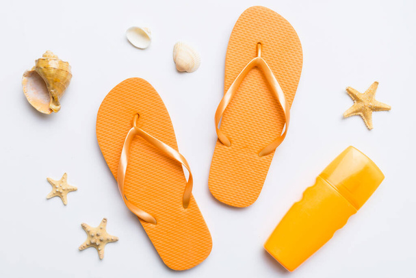 Flat lay composition with flip flops and seashell on colored background. Space for text top view. - Фото, изображение