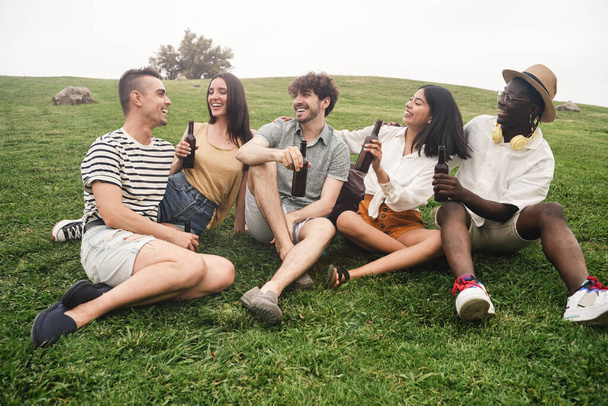 Junge afrikanische, lateinamerikanische und kaukasische Freunde, die im Sommer gemeinsam im Freien Spaß haben - Foto, Bild