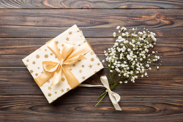 Gift or present box and flower gypsophila on light table top view. Greeting card. Flat lay style with copy space. - Fotografie, Obrázek