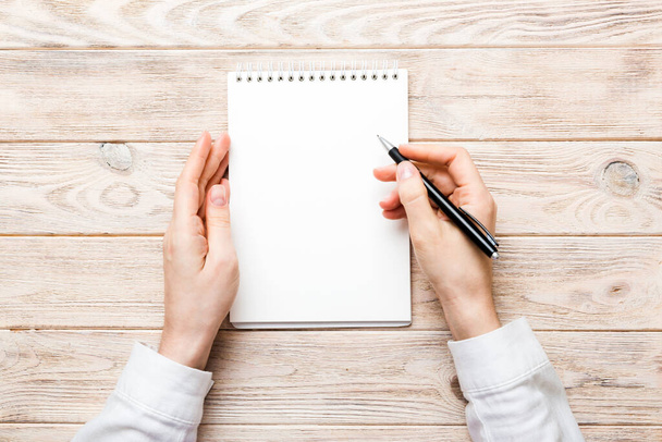 Woman hand with pencil writing on notebook. Woman working on office table. Female hand holding pencil and sketchbook. Mock-up Concept. - Foto, Imagen