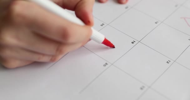 日付のための赤いハート型カレンダーで19日。女性は重要なカレンダーの日付をマーク - 映像、動画
