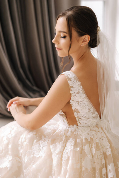 Vista laterale di bella sposa in elegante abito da sposa. Trucco e acconciatura splendidi. Foto di alta qualità - Foto, immagini