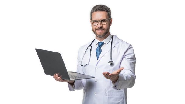 cheerful doctor promoting emedicine isolated on white. doctor offering emedicine in studio. doctor presenting emedicine on background. photo of emedicine and doctor man with laptop. - 写真・画像