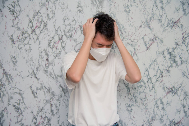 L'homme porte un masque facial mal de tête isolé sur fond blanc, concept de distance pandémique et sociale.Covid-19 - Photo, image