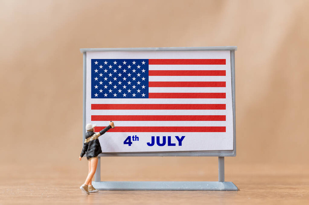 Minyatür insanlar, sanatçılar 4 Temmuz ve Bağımsızlık Günü 'nün ilan panosunda resim yapıyorlar. - Fotoğraf, Görsel