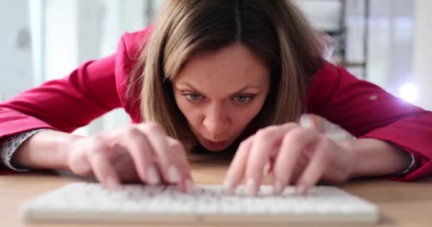 Mujer cara enojada en la mesa con el ordenador y el teclado. Comentarios negativos y acoso cibernético en Internet - Metraje, vídeo