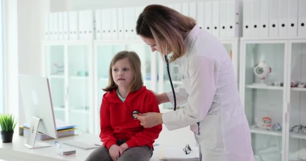 Lastenlääkäri kuuntelee pienen tytön keuhkoja stetoskoopilla. Lasten terveydentilan seuranta - Materiaali, video