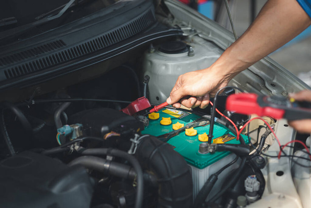 Professionele monteur controleren van de auto van de klant elektrisch systeem gebracht voor reparatie, alle soorten auto specialisten, deskundige auto reparaties en gecertificeerde auto reparatiecentra. - Foto, afbeelding