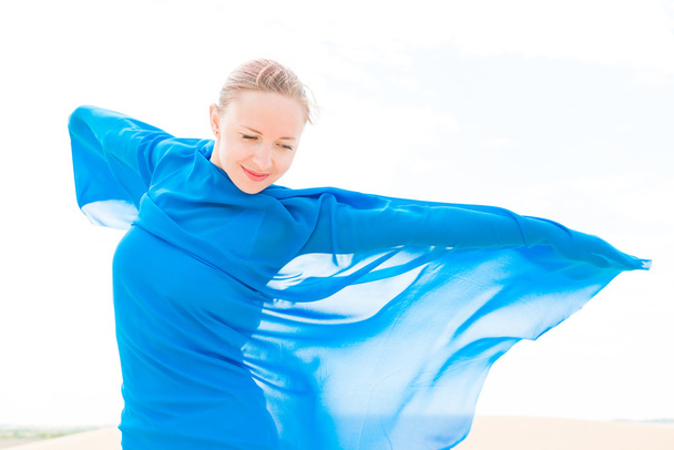 Young woman with flying blue scarf - Фото, зображення