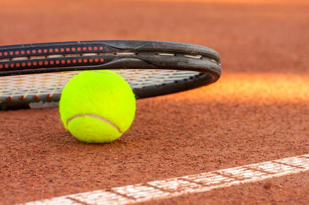 Μπάλα τένις και ρακέτα σε γήπεδο τένις πηλό - Φωτογραφία, εικόνα
